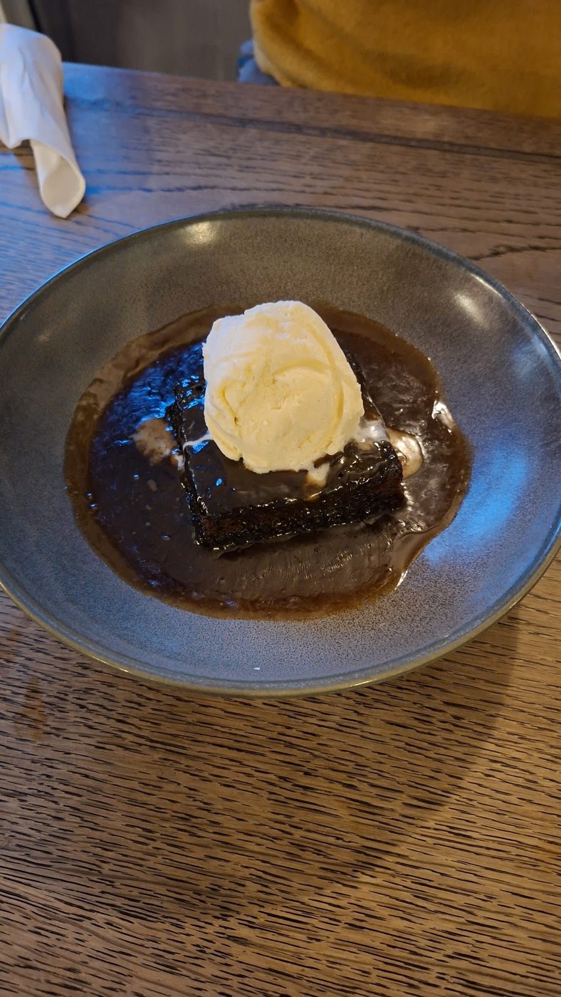 A dessert with ice cream in a dark bowl